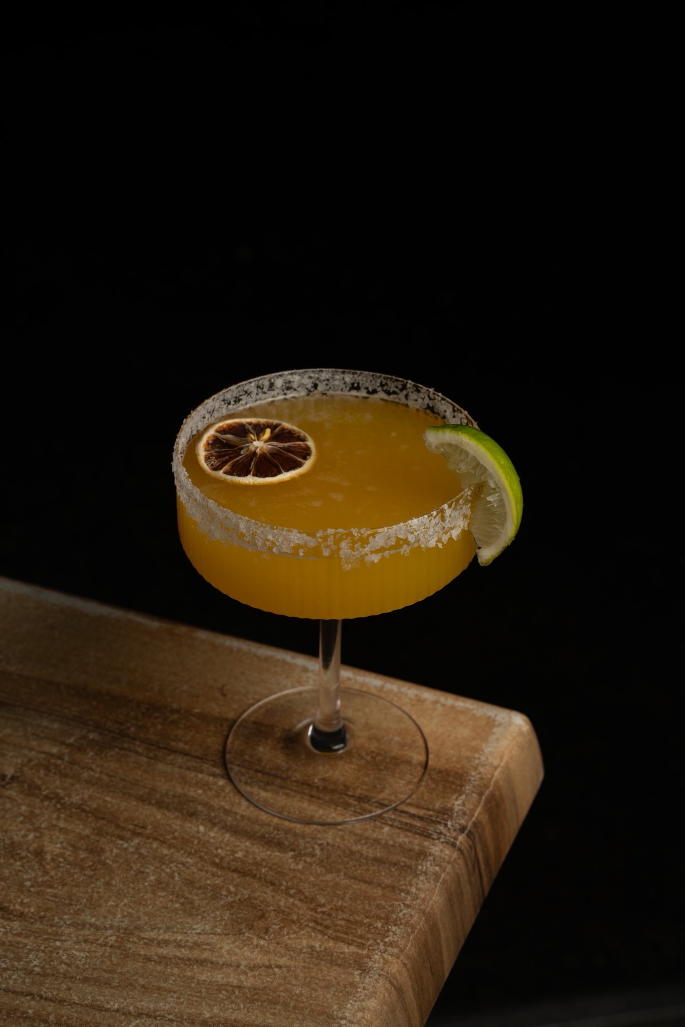Orange citrus cocktail in a coupe glass with salted rim at Little Elm Cafe