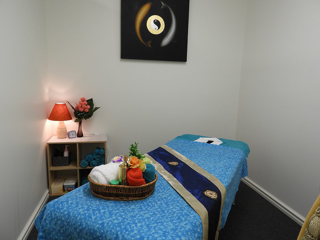 Warm treatment room with blue star fabric massage table at Golden Orchid Thai Massage