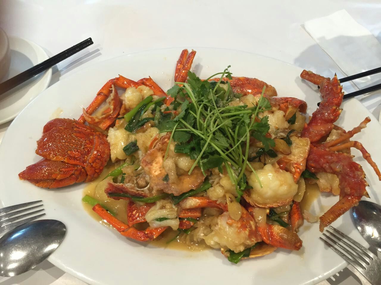 Stir-fried lobster with ginger and scallion sauce garnished with fresh coriander