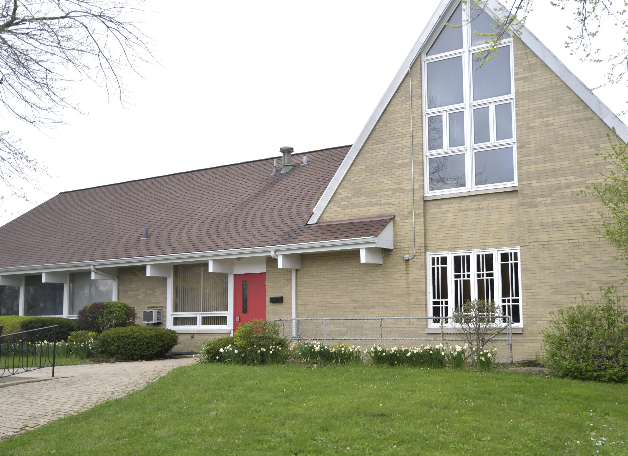 Lake Villa United Methodist Church exterior, spring with daffodils and red door