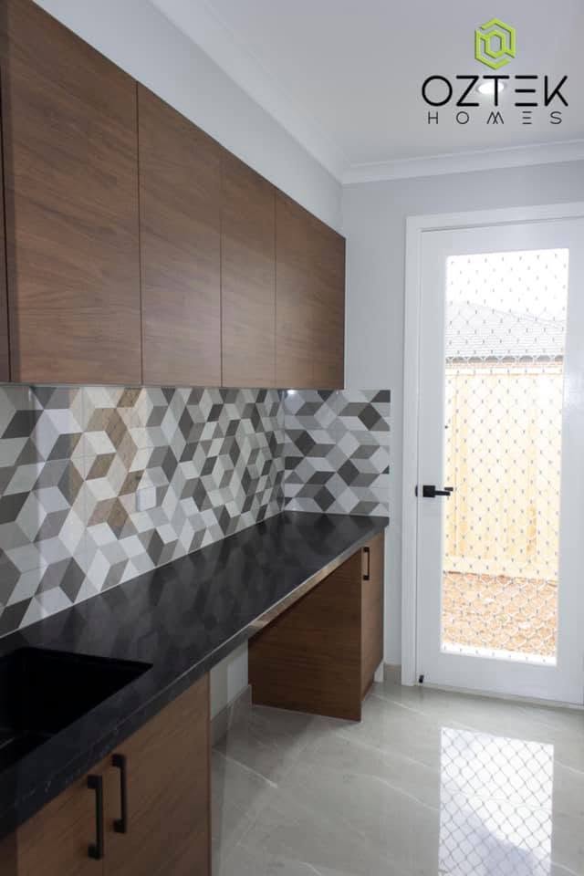 Butler's pantry with geometric tile backsplash and walnut cabinetry