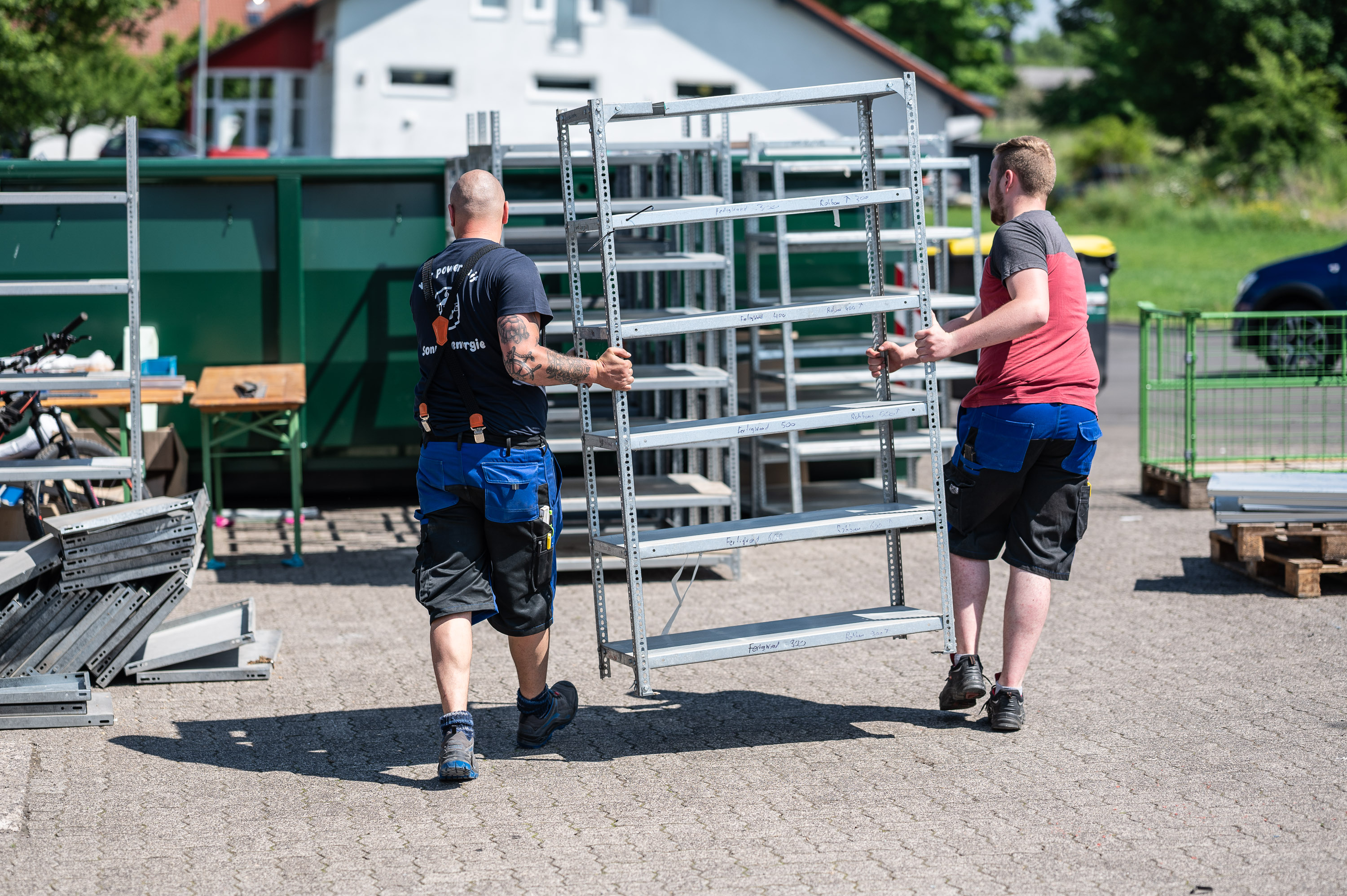 Zwei Mitarbeiter tragen Regal beim Lagerumzug