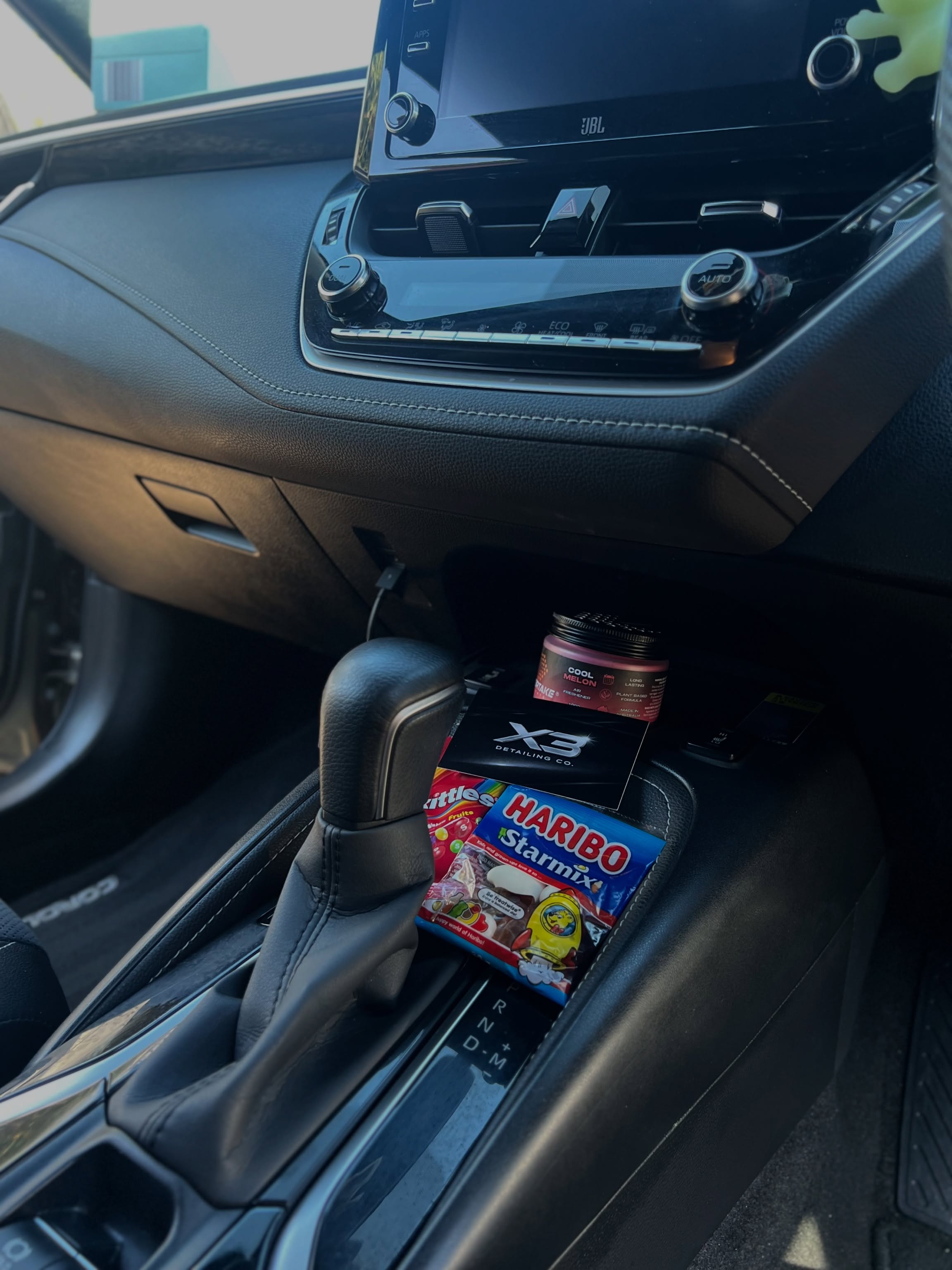 X3 Detailing Co. business card and air freshener placed inside a freshly detailed car