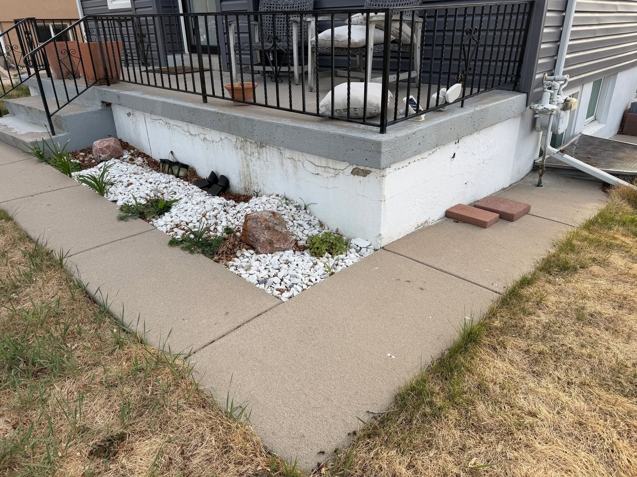 Before shot of a concrete porch foundation with cracked and peeling paint requiring surface preparation