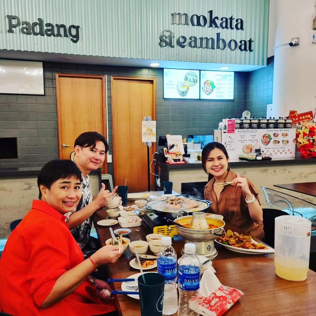 Guests enjoying mookata at a table with the full steamboat and grill setup