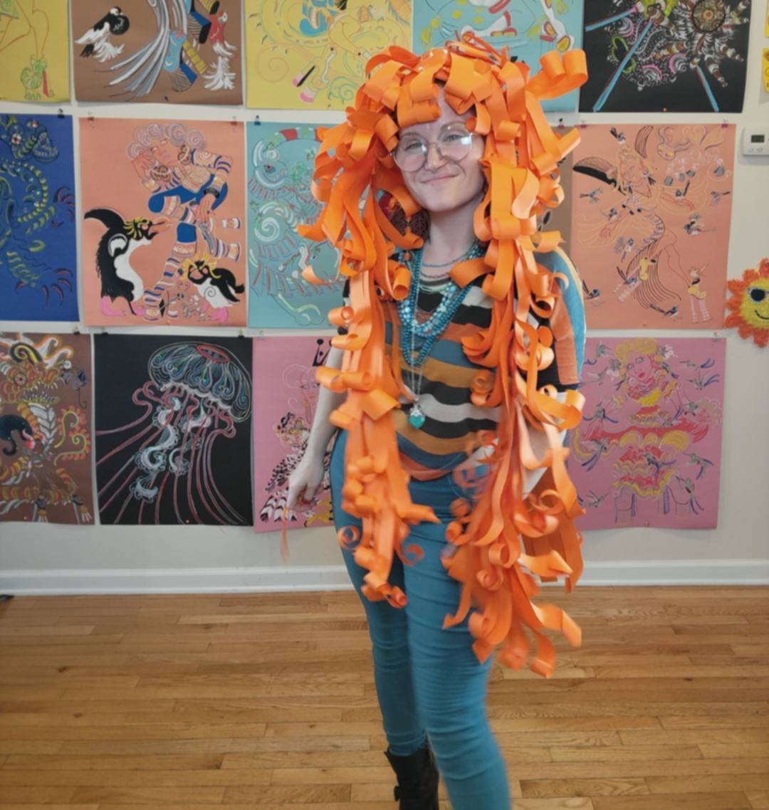 Donna Marie Milligan wearing a flowing orange paper wig with waist-length strips.