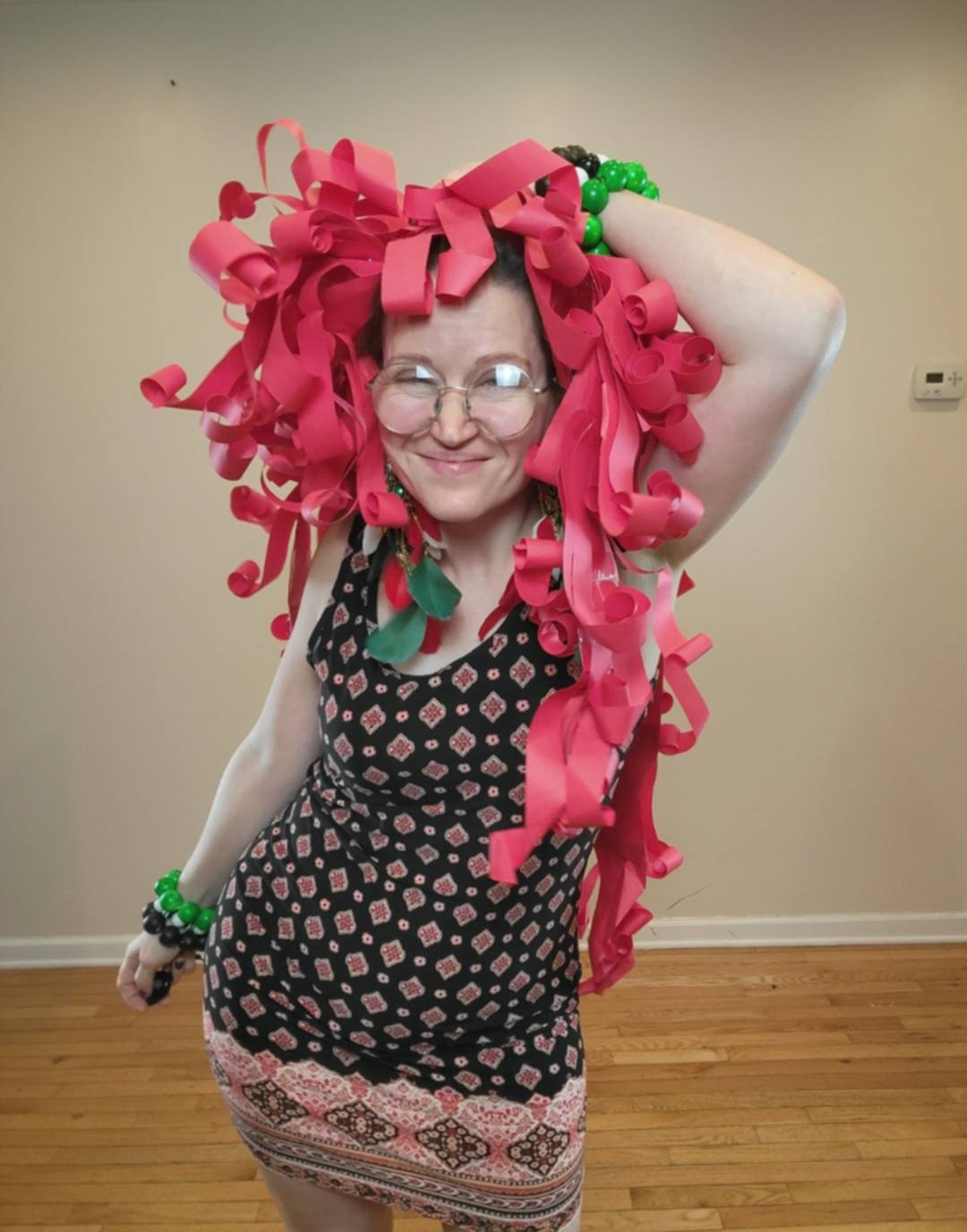 Donna Marie Milligan wearing a hot-pink paper wig with cascading curled strips.