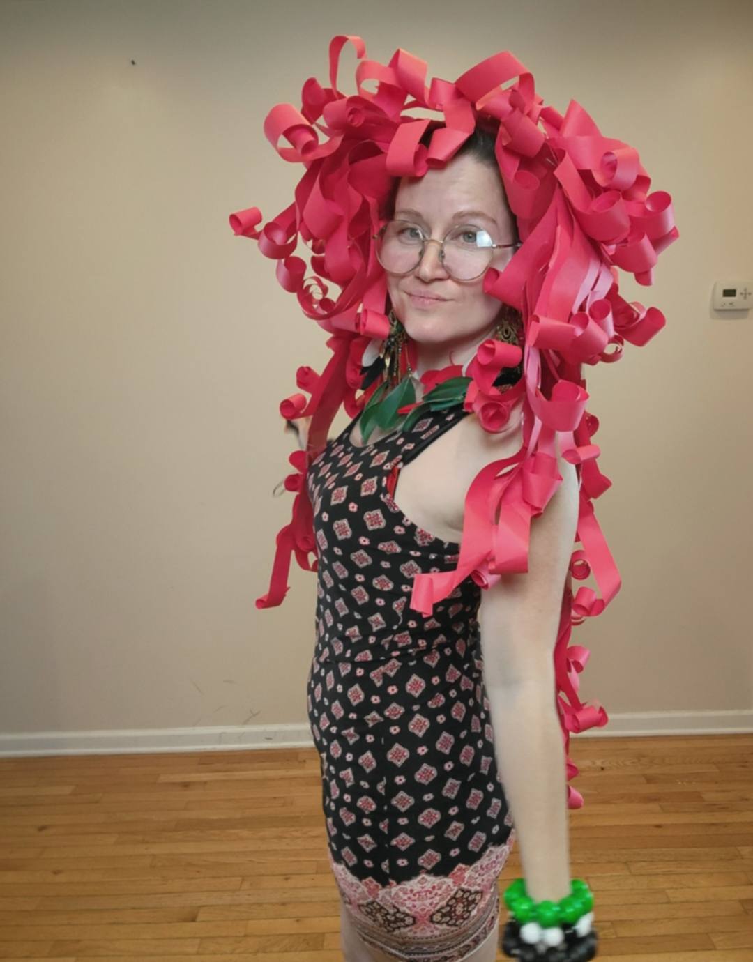 Donna Marie Milligan wearing a deep-rose paper wig with long flowing curled strips.