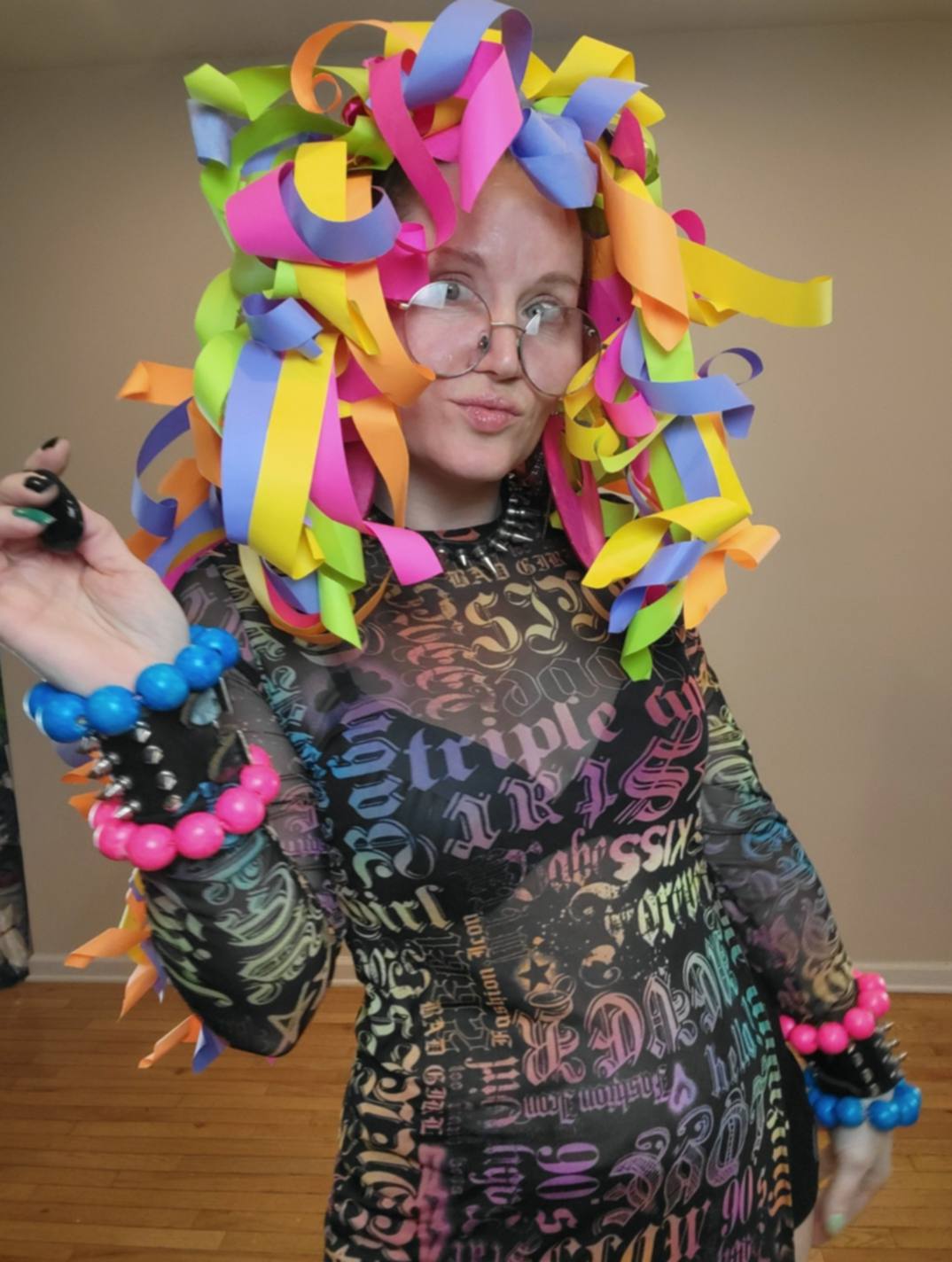 Donna Marie Milligan wearing a rainbow paper wig made from chunky curled paper loops.