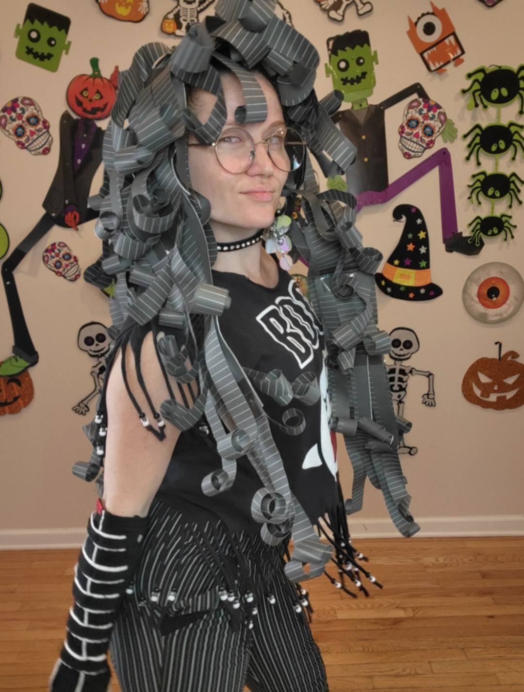 Donna Marie Milligan wearing a dark pinstripe paper wig with dense dramatic ringlets.