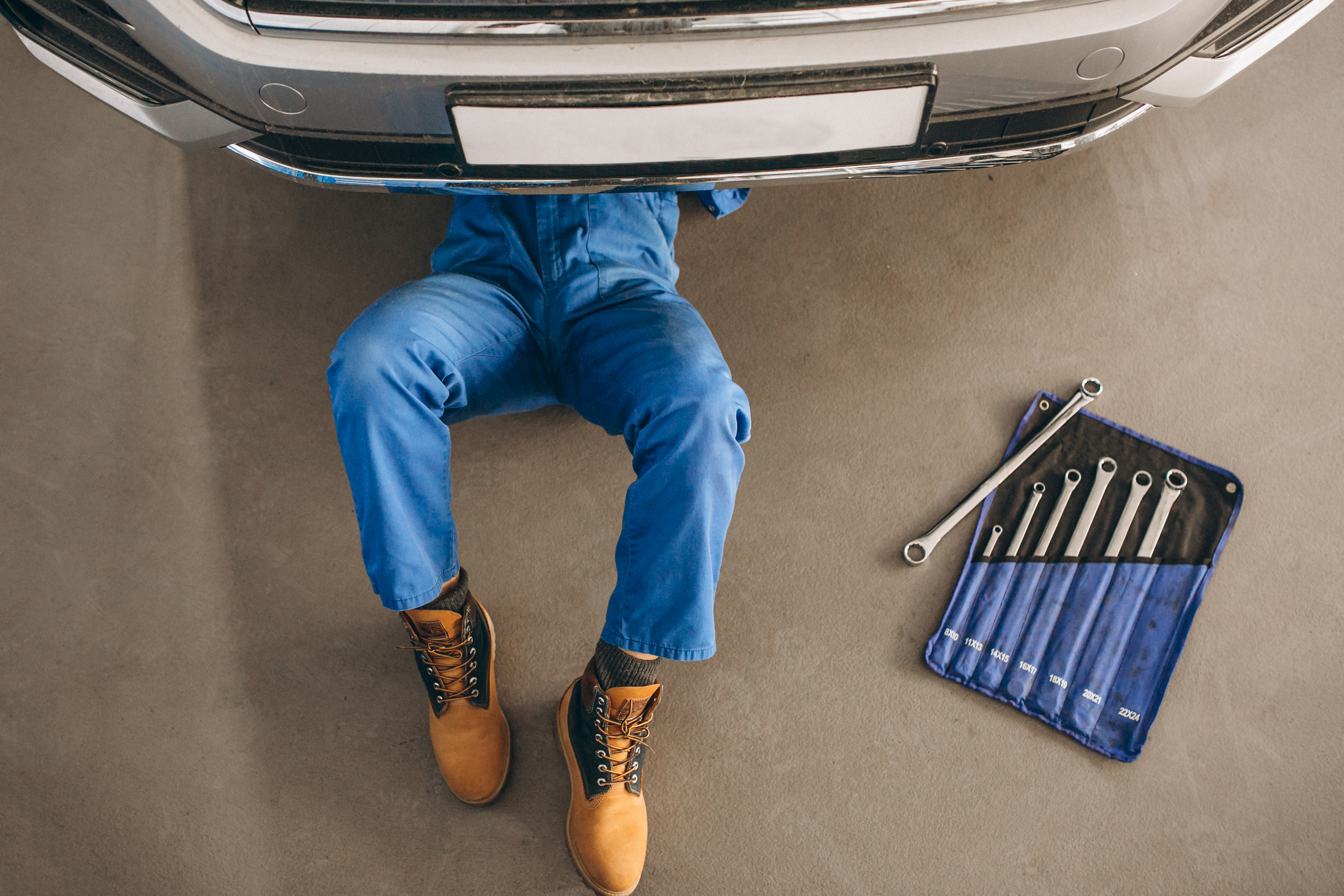 Professional mechanic working under car