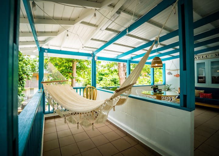 Hammock hanging on the blue-beamed terrace with jungle views