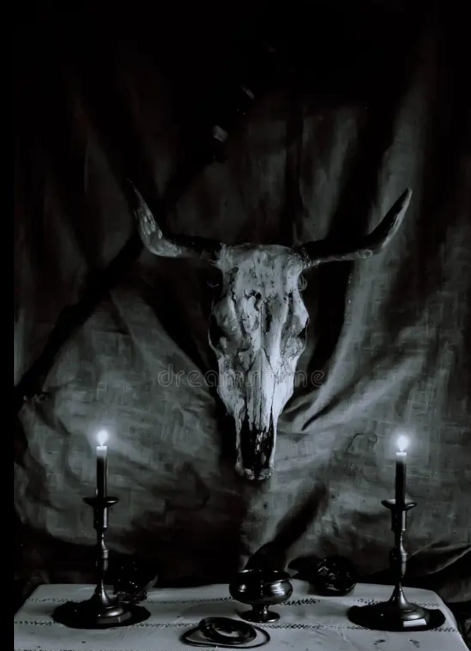 Altar oscuro con calavera de toro y velas