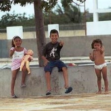 Drei Kinder auf einer Mauer am Stadtplatz