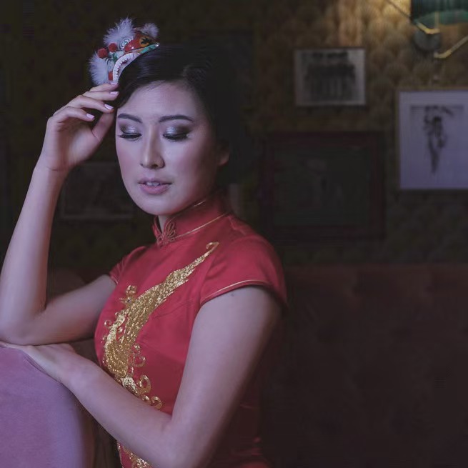 Traditional Chinese qipao styling with lion dance headpiece