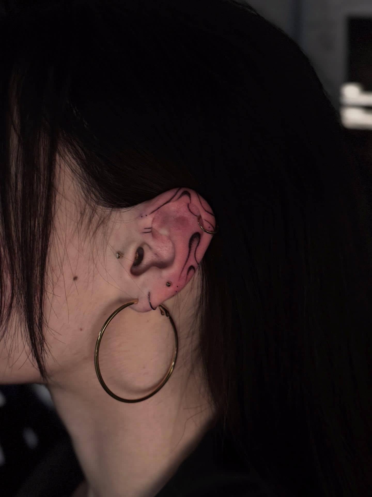 Fineline Ohr-Tattoo mit schwarzen Linien