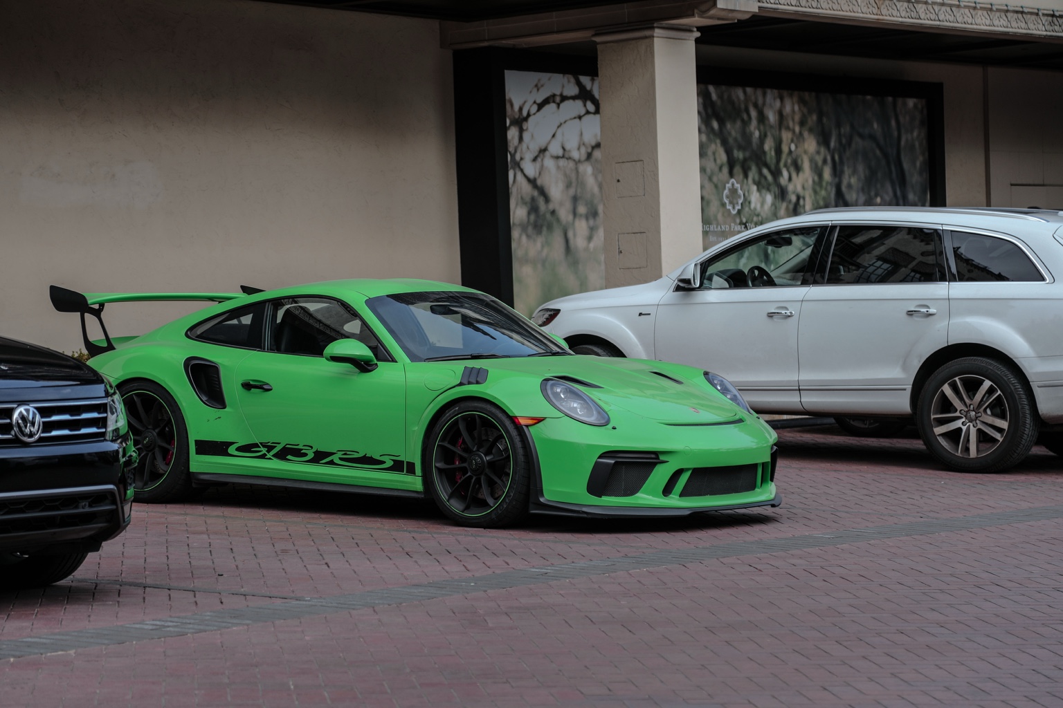 Bright green Porsche 911 GT3 RS parked on brick pavers in Highland Park