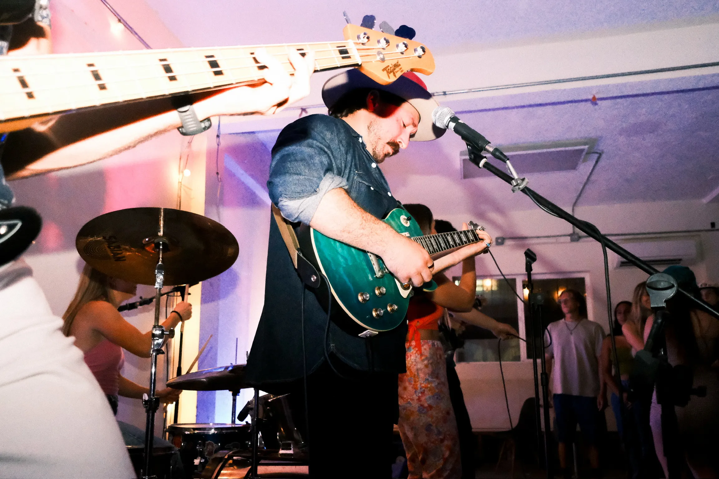 Guitarist performing with teal Les Paul