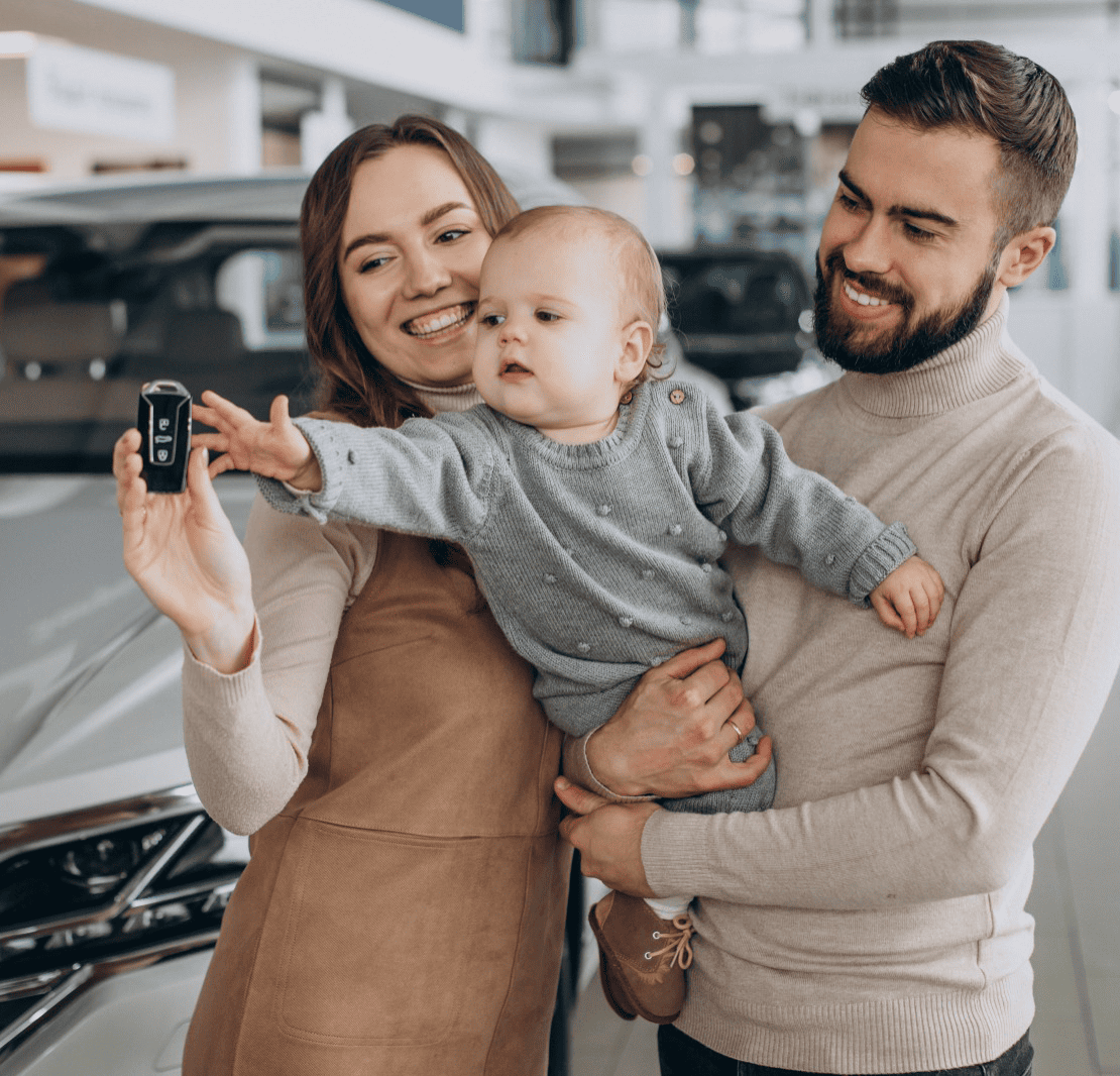 Familia con bebé recibiendo las llaves de su nuevo auto en Giama Plan