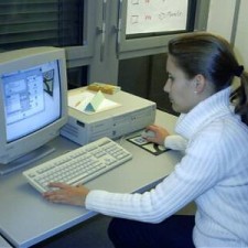 Junge Frau arbeitet allein am Computer-Arbeitsplatz