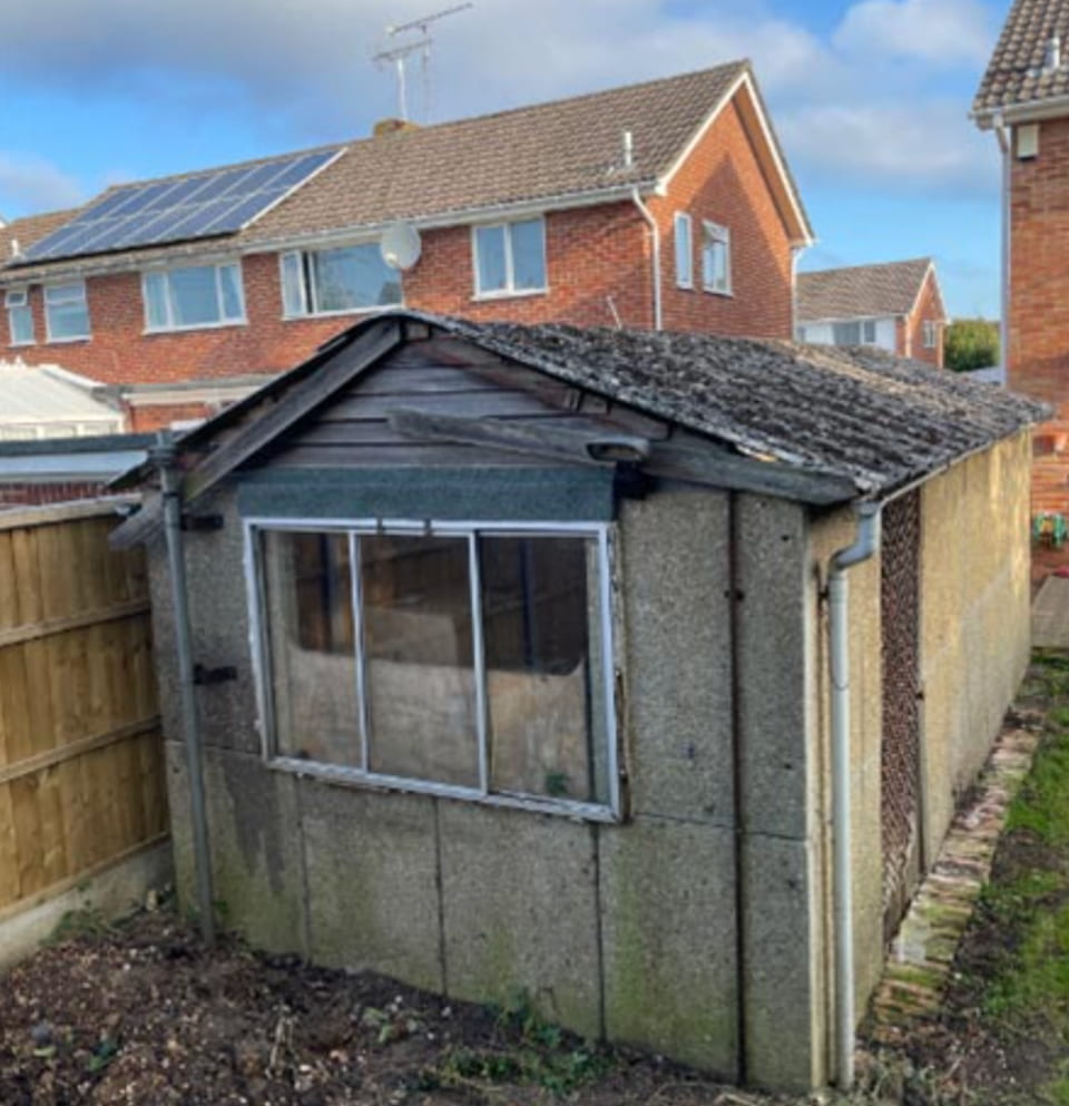 Old garage with asbestos cement roof before removal