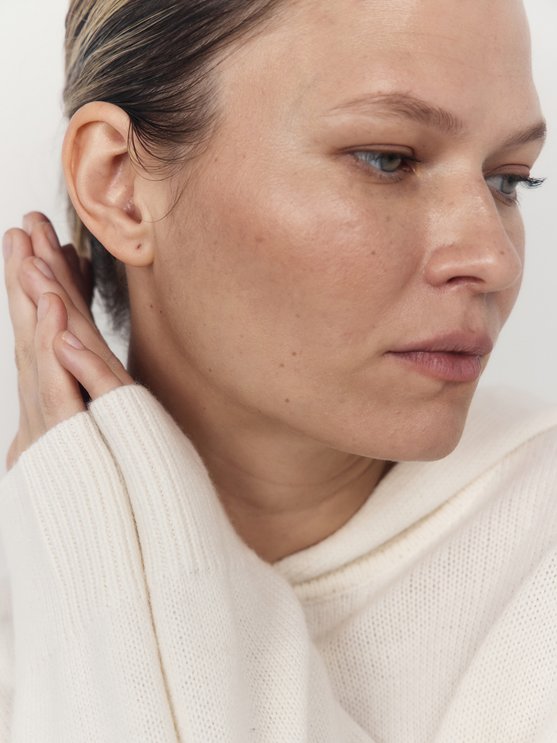 Beauty close-up before retouching — cream turtleneck, natural freckled skin