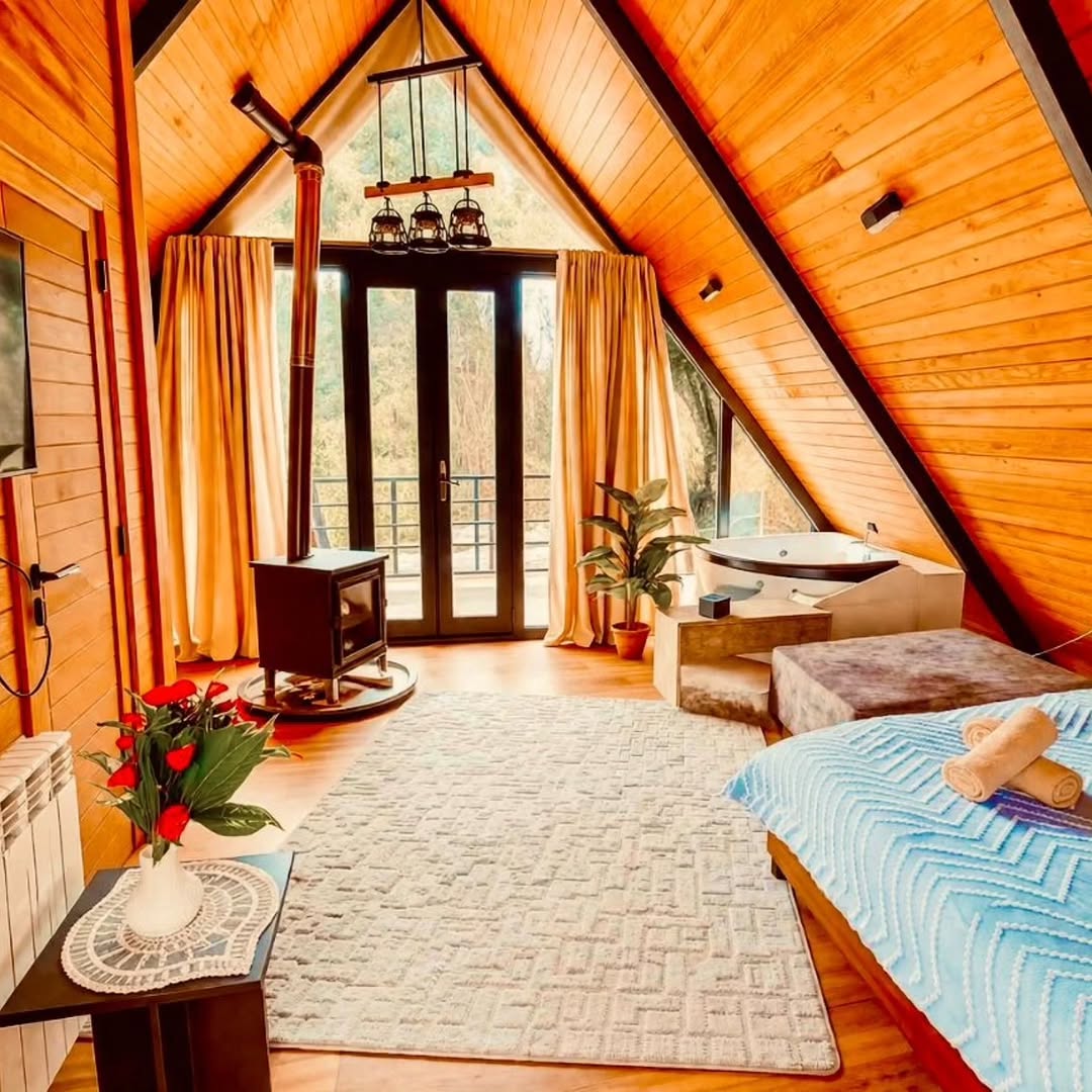 Cozy A-frame interior with wood stove and jacuzzi