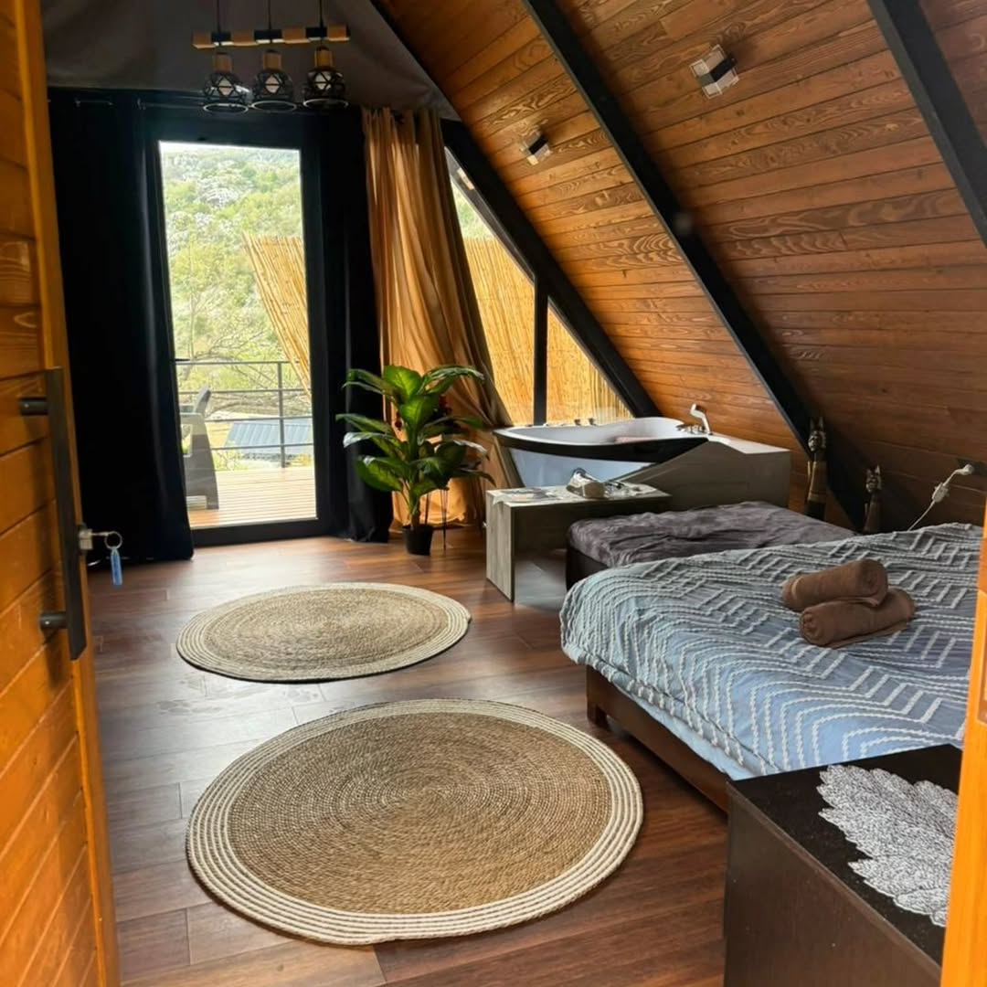 Cozy bedroom with jute rugs, bathtub, and natural light