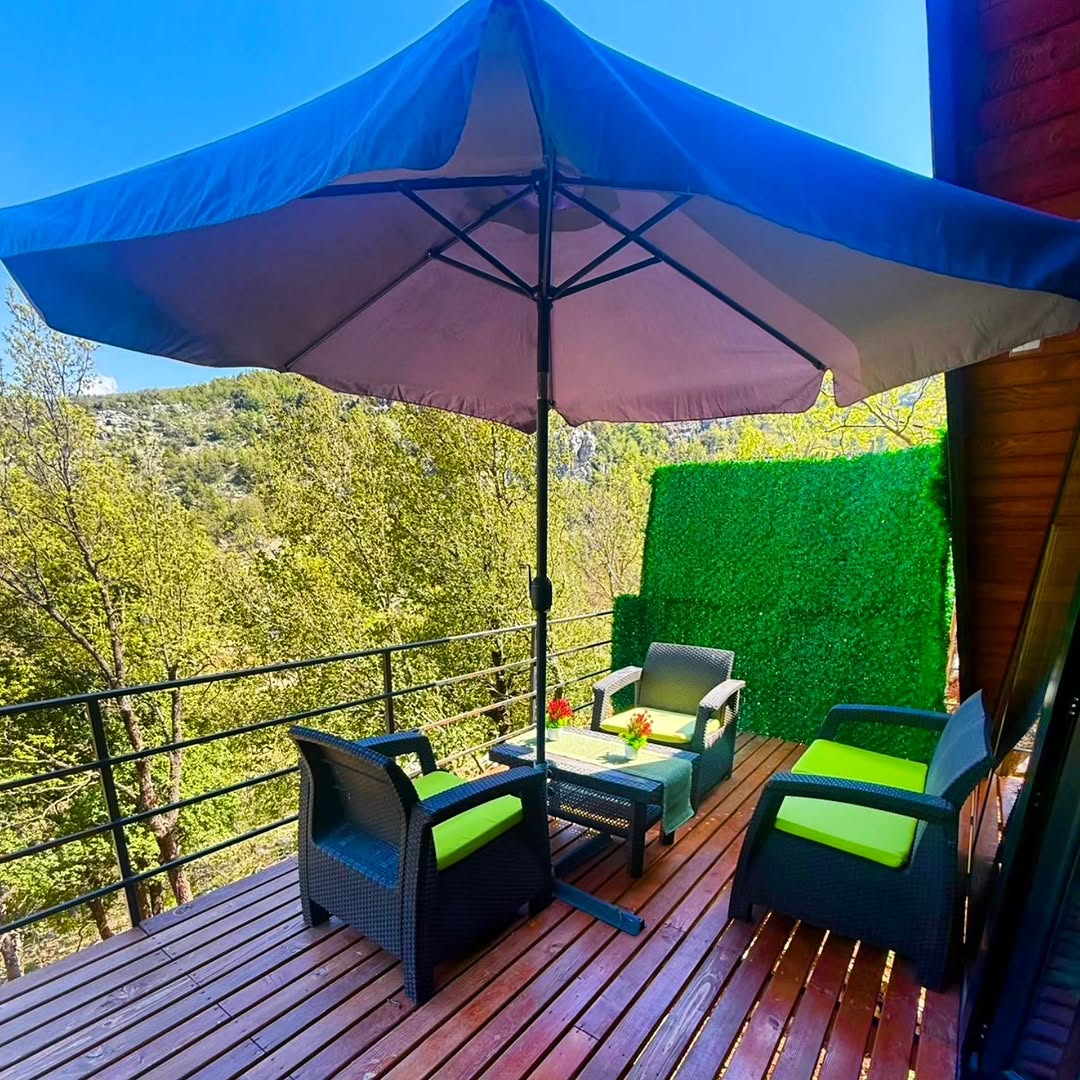 Terrace with umbrella, seating, and forest views