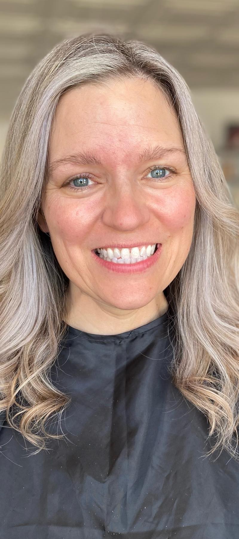 Smiling woman with natural silver-blonde wavy hair
