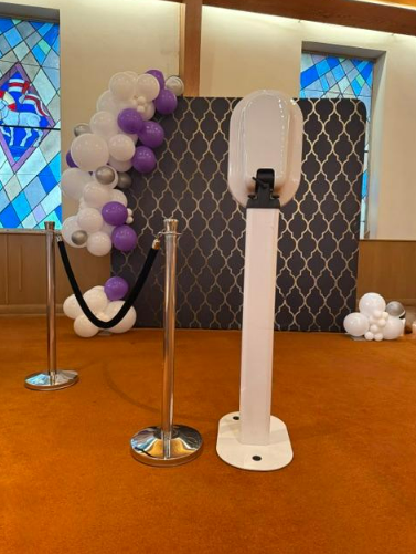 Photo booth setup with moroccan backdrop and purple white balloon garland church venue Nashville