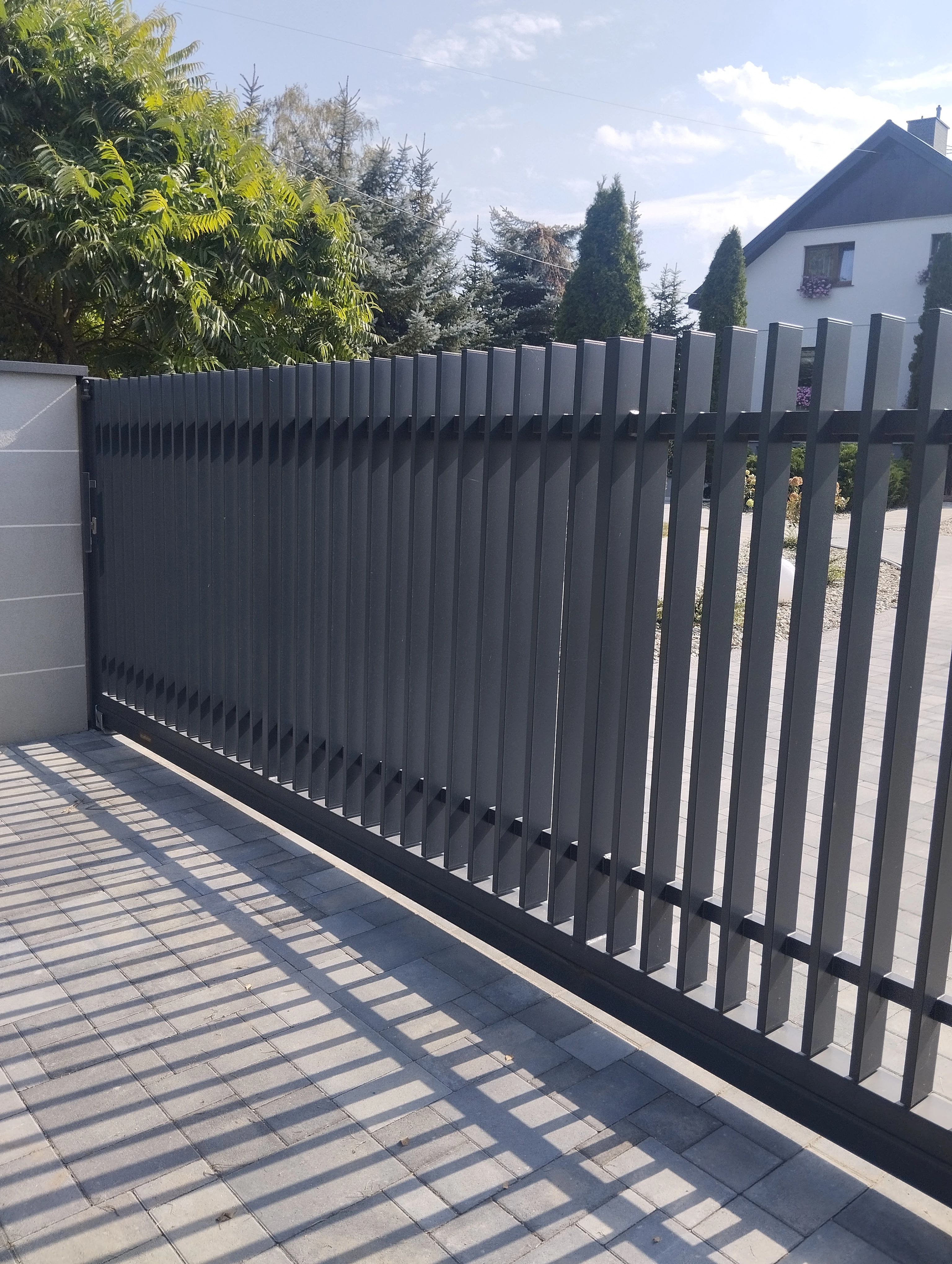 Elegant sliding gate with vertical slats in dark gray