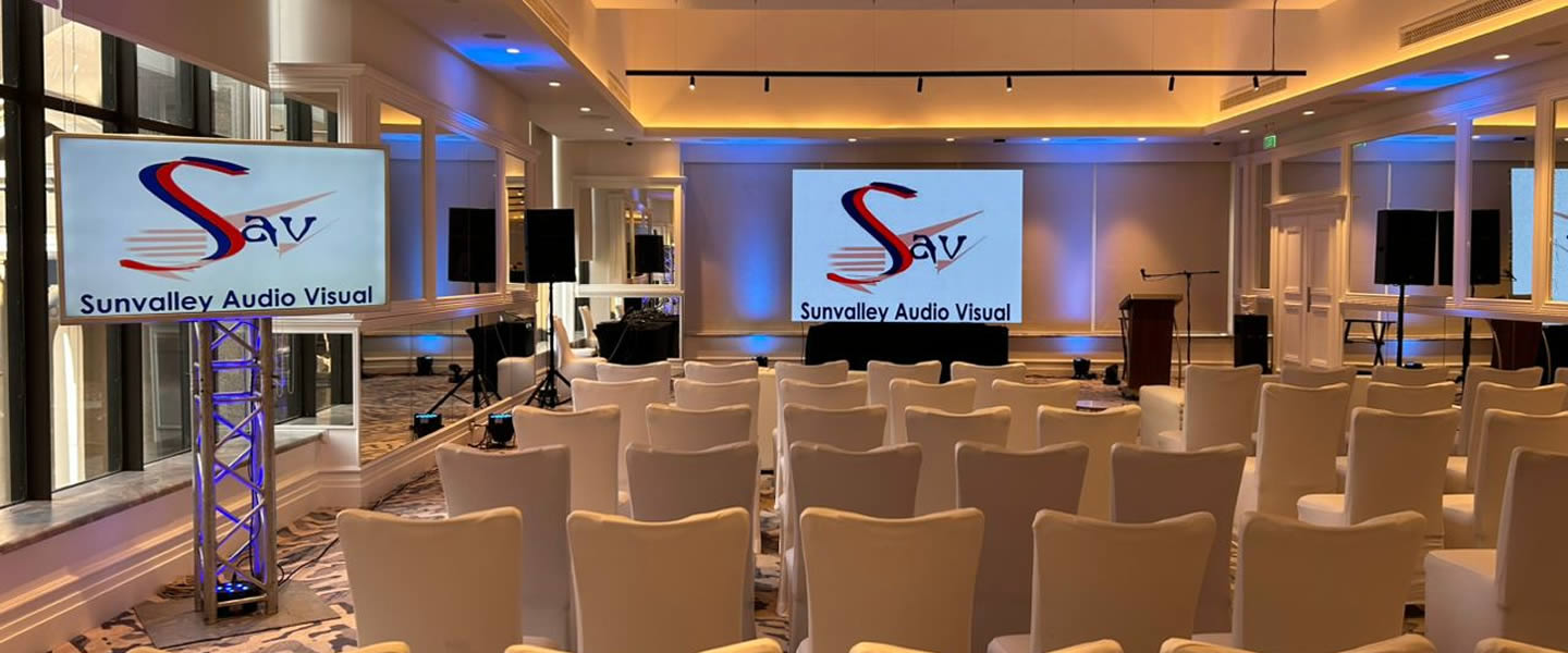 Premium ballroom event with dual LED screens displaying Sunvalley branding and professional staging