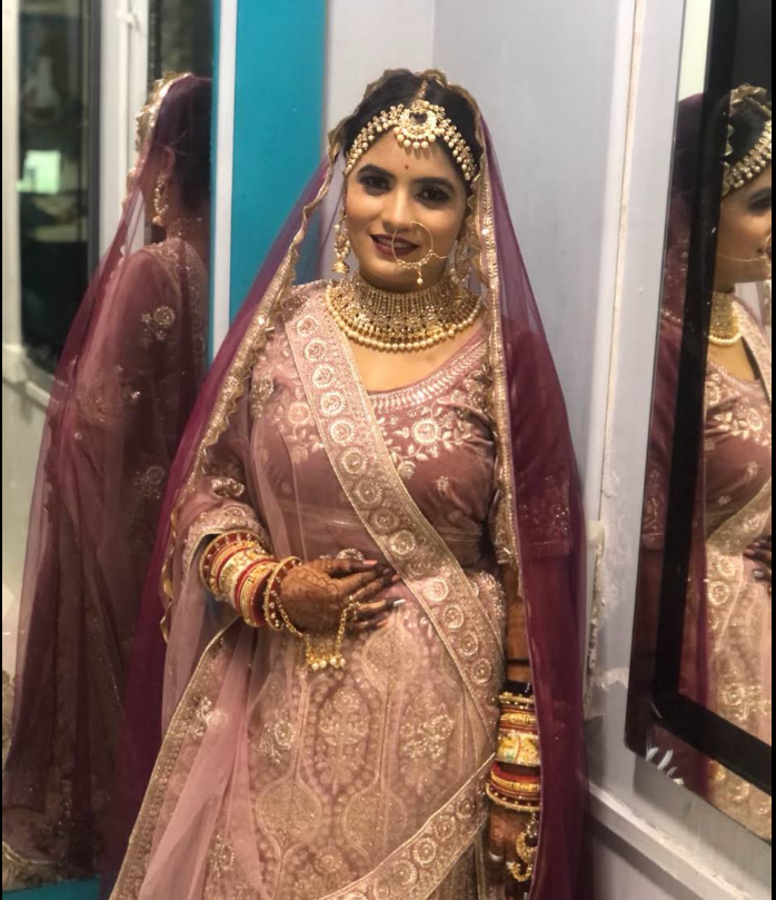 Bride in dusty-mauve lehenga with gold jewelry at Kaizen