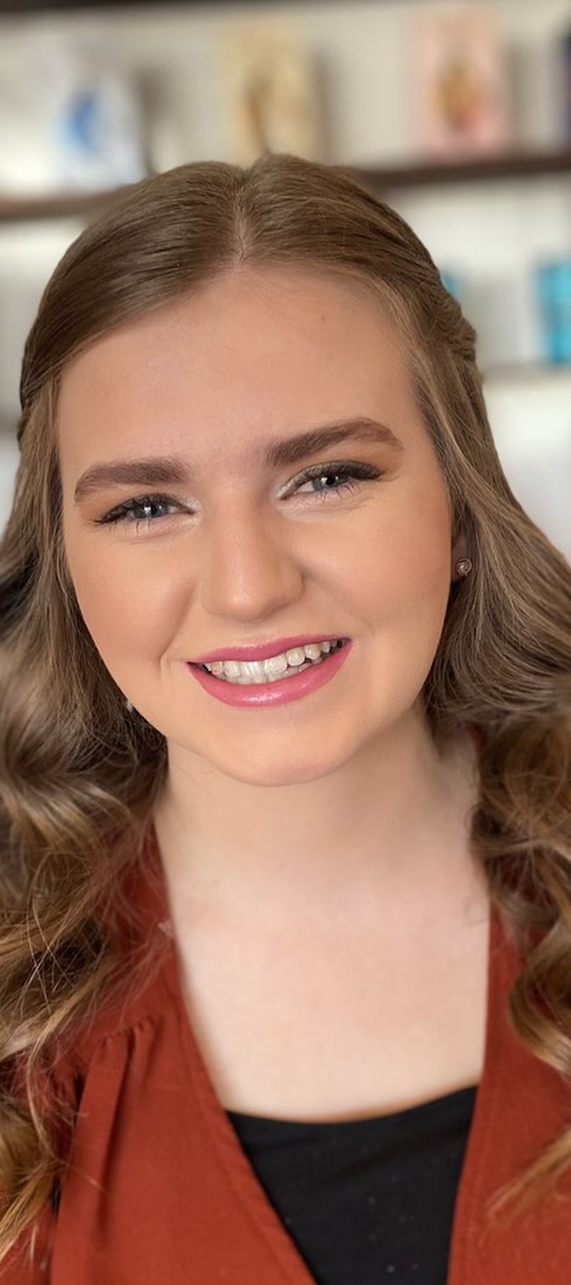 Smiling woman with warm brunette wavy hair, bookend right