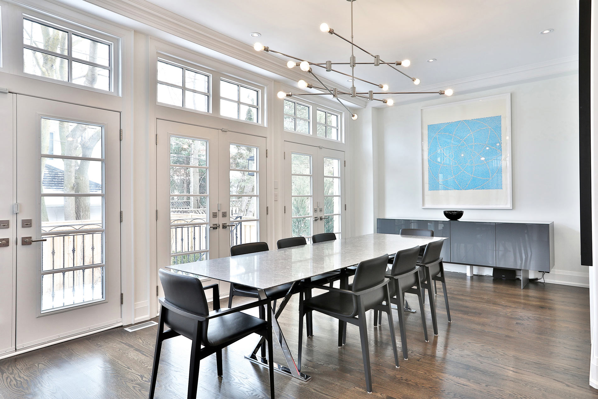 Bright dining room with marble table and floor-to-ceiling windows