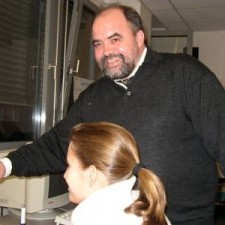 Mann mit Bart steht hinter Mädchen am Computer-Arbeitsplatz