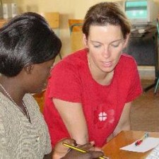 Trainerin erklärt einer Teilnehmerin einen Lerninhalt am Tisch