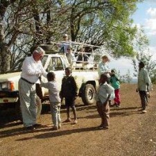 Fairnetzen-Team verteilt Materialien aus einem Geländewagen an Kinder auf einem Feldweg