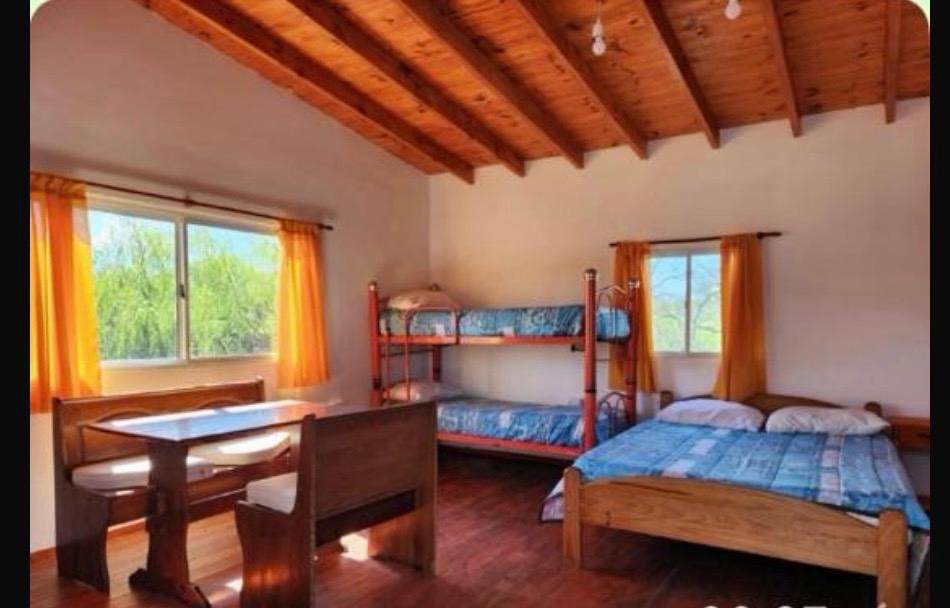 Habitación con camarotes, cama doble y mesa — cabaña 4 personas