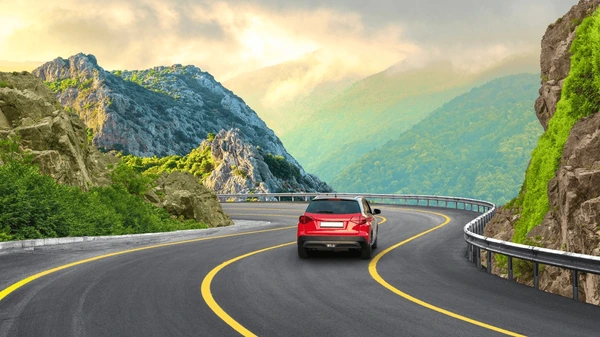 Red car driving on scenic mountain road in Morocco