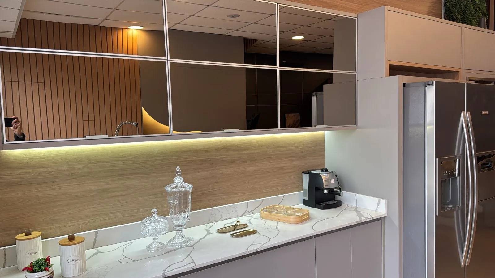 Cozinha com armários espelhados e bancada de mármore
