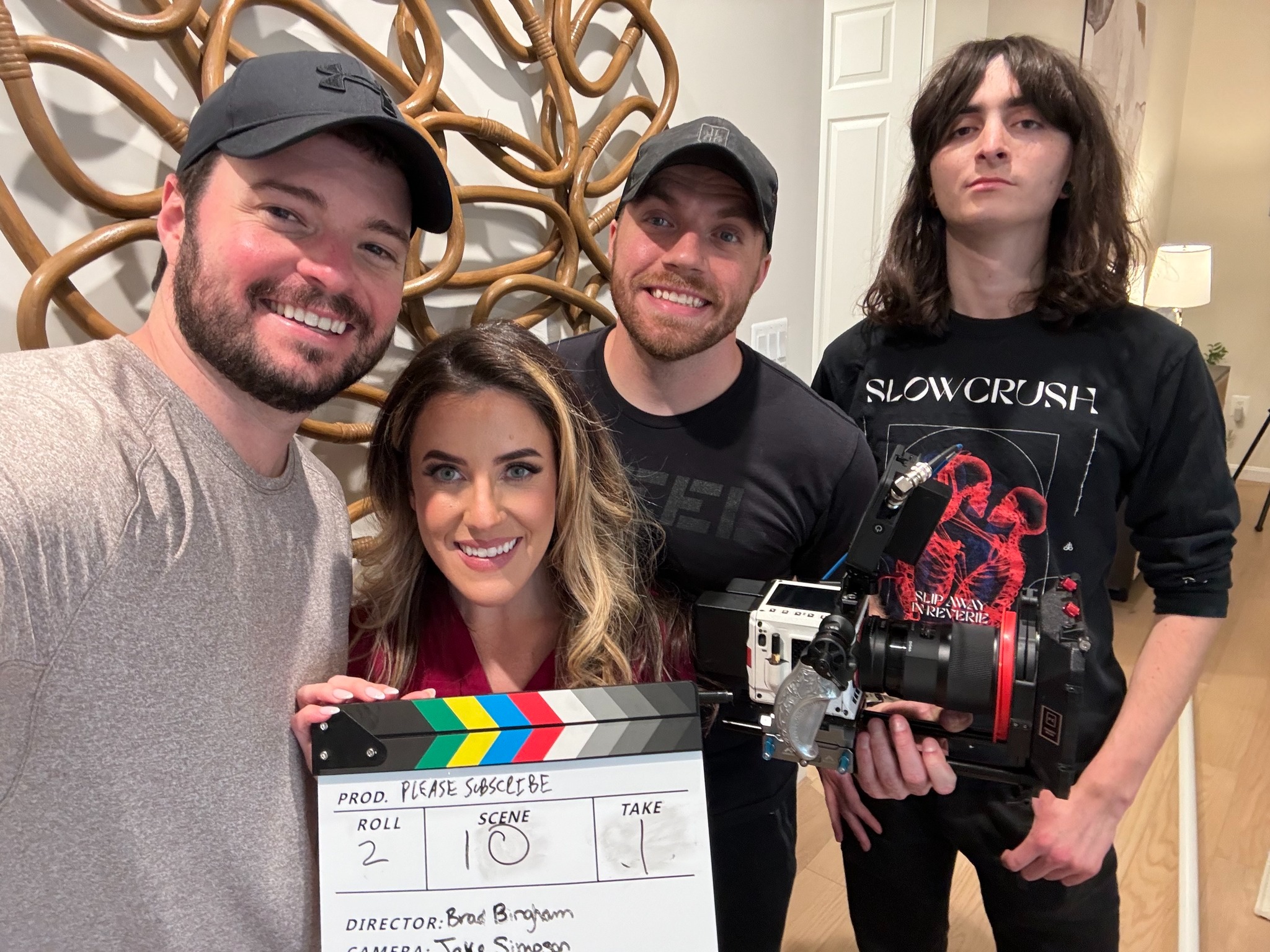 Cast and crew with clapperboard on set of Please Subscribe