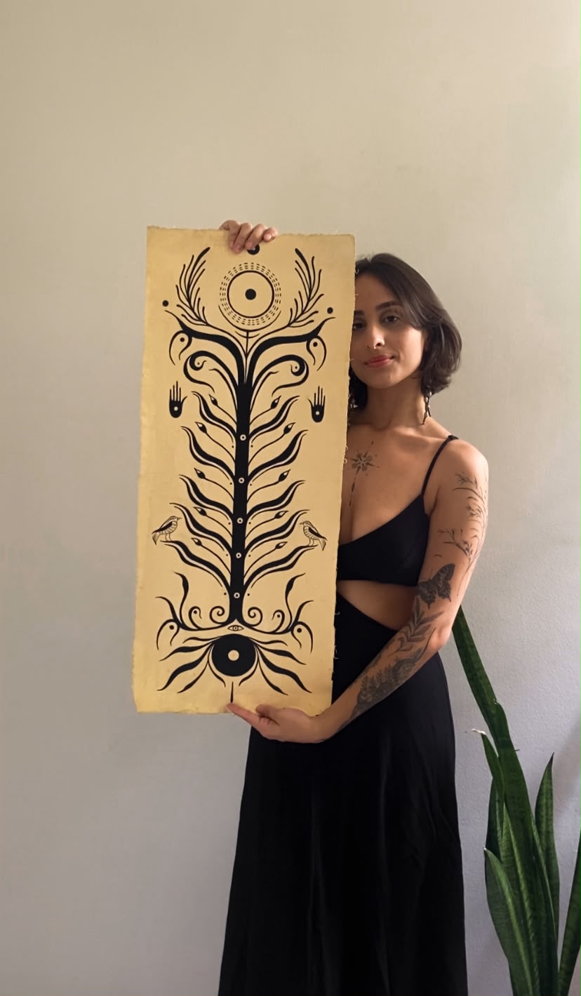 Cecília segurando uma grande pintura ornamental em nanquim
