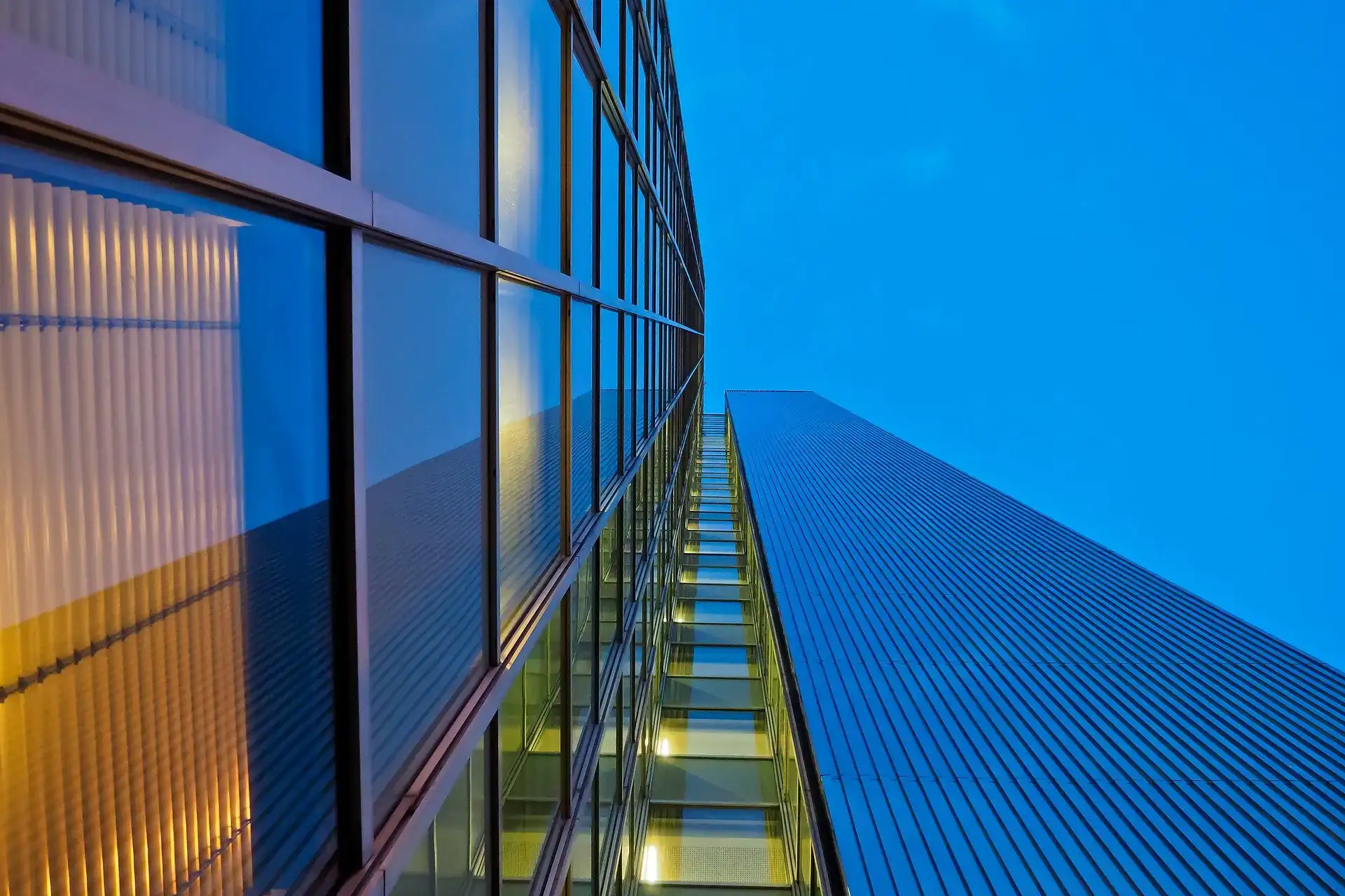 Modern office building with glass windows against blue sky