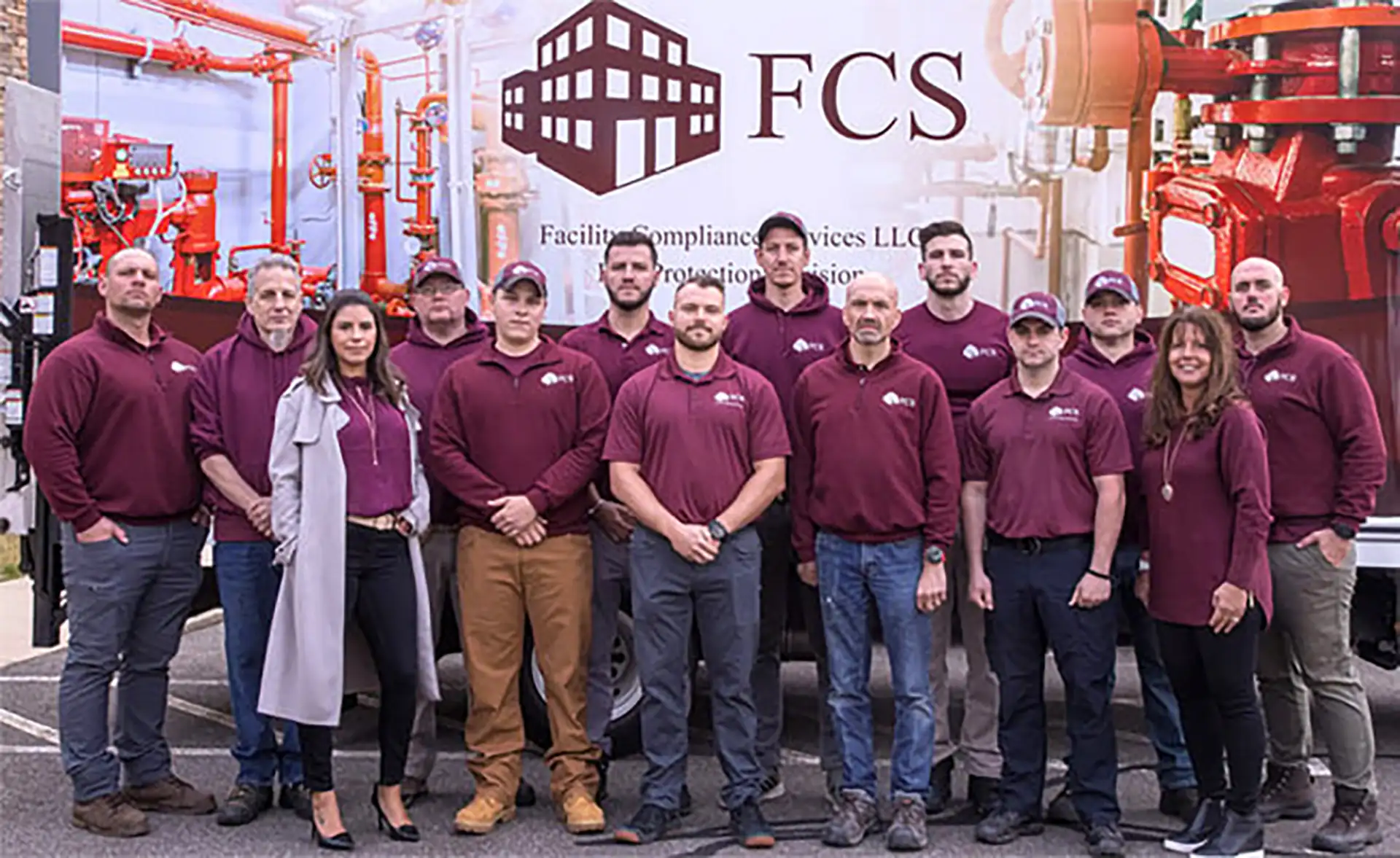 Full FCS team group photo in front of branded vehicle