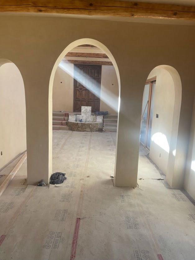 Interior with multiple arched doorways and smooth plaster walls