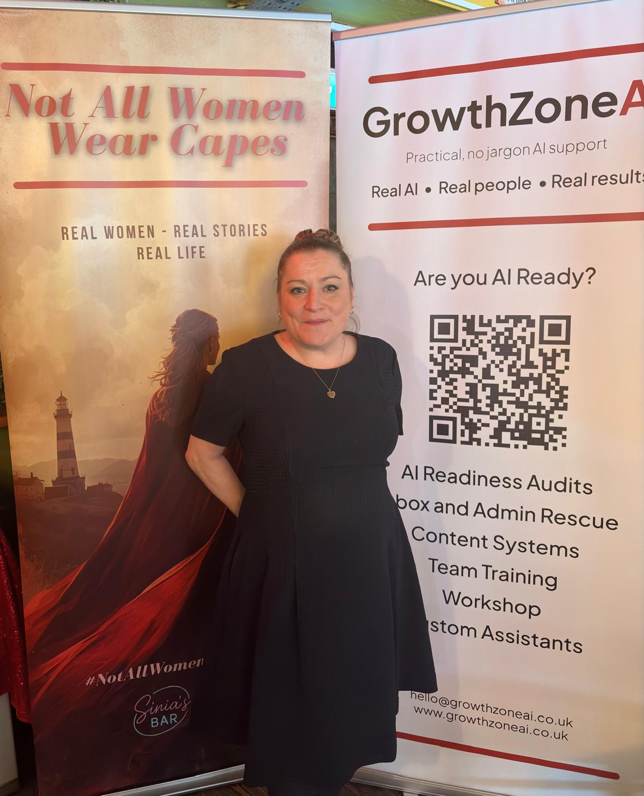 Kaye Nicholson standing in front of the #NotAllWomenWearCapes and GrowthZone AI banners at a community networking event