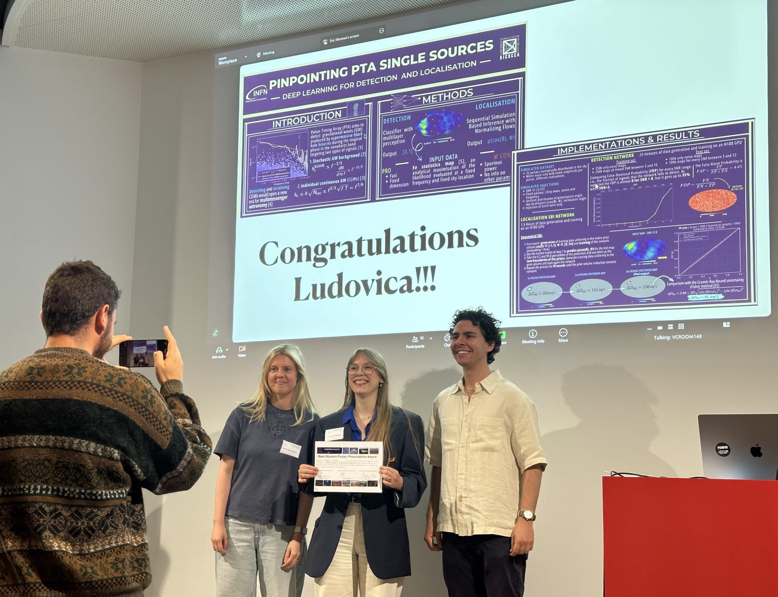 A winner receiving the Best Student Poster Presentation Award on stage, with the winning poster shown on screen