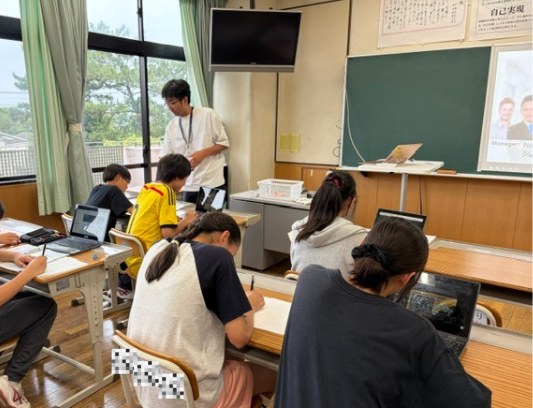 教室で生徒の机間を回りながら助言する先生